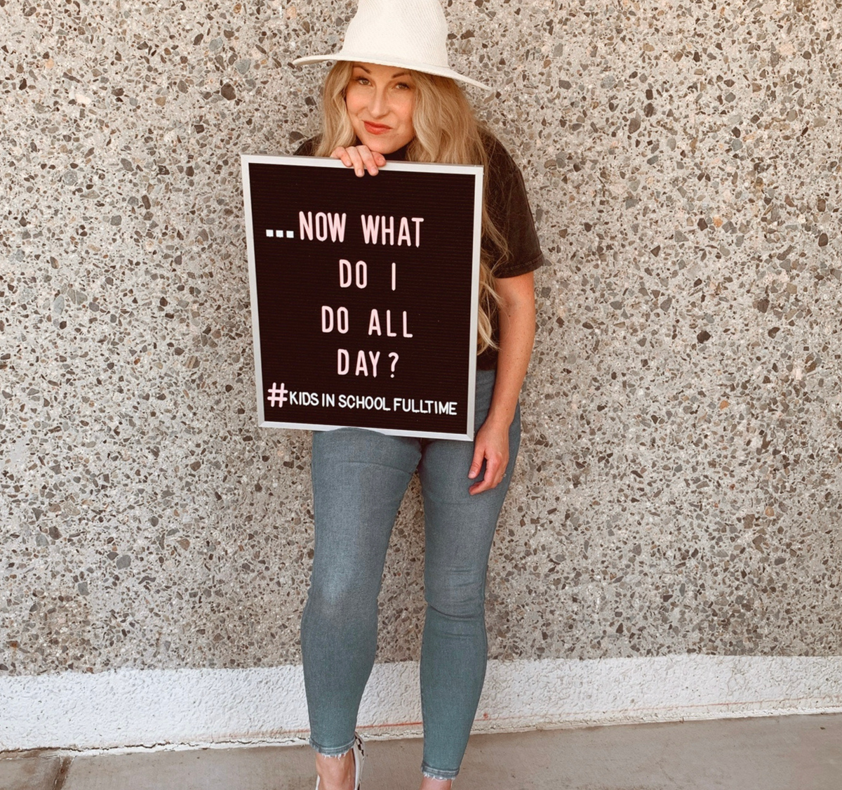 Woman holding a letter board reading “Now What Do I Do All Day?” with “Kids in School Full Time” below.