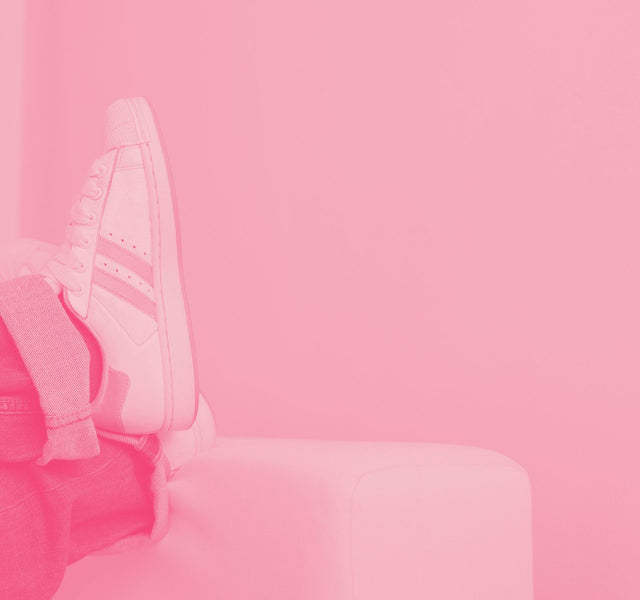 Pink-tinted photo of a backpack resting on a bench.