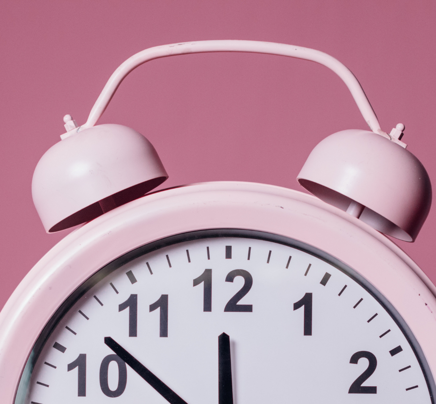 Close-up of a pink twin-bell alarm clock.