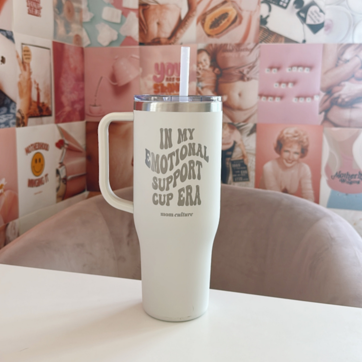 White handled tumbler reading “In My Emotional Support Cup Era” in front of a pink collage wall.