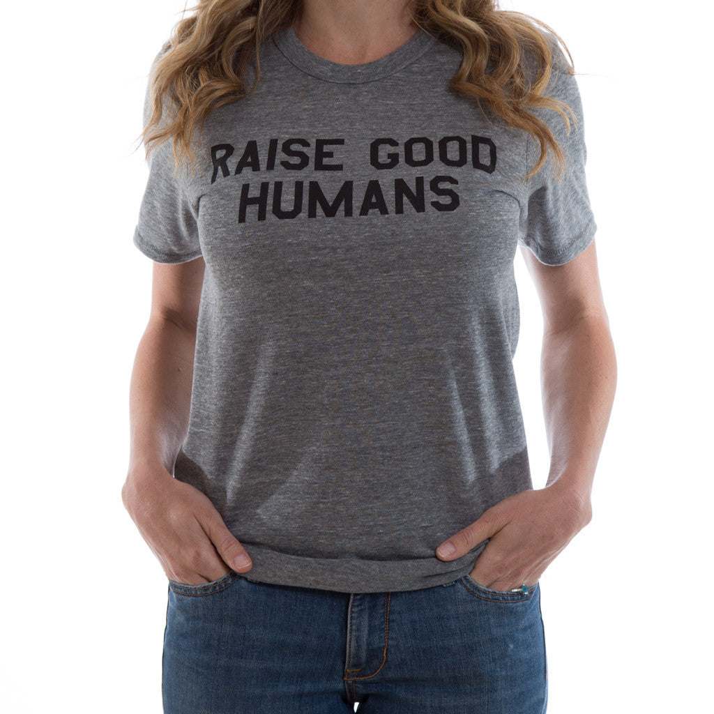 Woman wearing a heather gray crewneck T-shirt with black “Raise Good Humans” lettering.