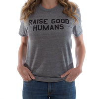 Woman wearing a heather gray crewneck T-shirt with black “Raise Good Humans” lettering.