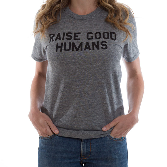 Woman wearing a heather gray crewneck T-shirt with black “Raise Good Humans” lettering.