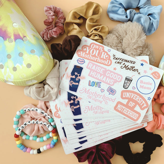 Mom Culture sticker sheets surrounded by scrunchies and colorful bracelets.